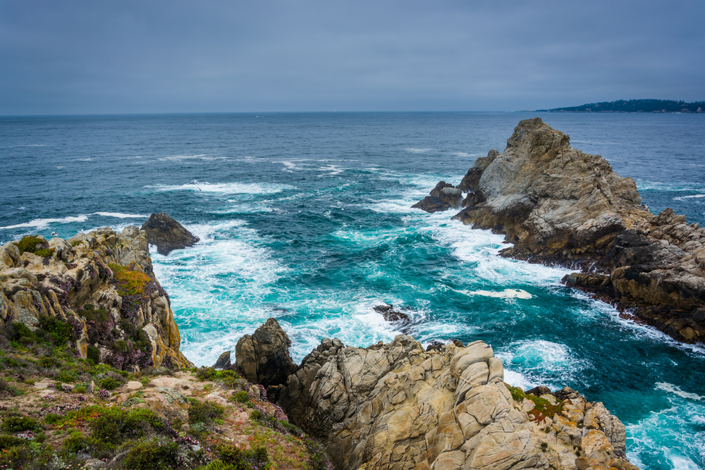 Large rocks and waves in the Pacific Ocean, seen from a beach at Point Lobos State Natural Reserve, in Carmel, California.
